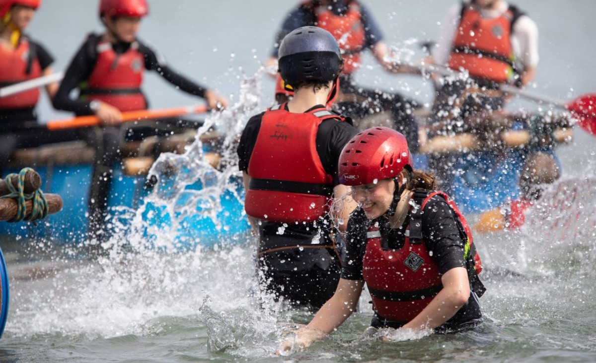 Children splashing in the water during Raft Racing at Chichester Harbour, West Sussex